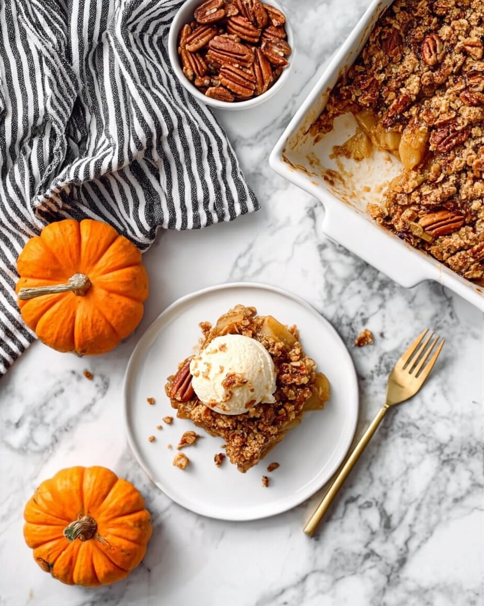 A white plate sits on a white marbled surface, holding one square piece of apple crisp topped with a scoop of melting vanilla ice cream. The apple crisp has visible chunks of cooked apples and a golden brown crumbly topping, with a sprinkle of pecans. Next to the plate, a white woman’s hand is holding a gold fork, ready to dig in. Three small orange pumpkins and a small bowl filled with pecans are placed nearby, adding a cozy autumn feel. A white baking dish with more apple crisp is positioned above, showing the same crumbly top and baked texture. A black and white striped cloth is partially visible on the left side. The overall image has a warm and inviting look. photo taken with an iphone --ar 4:5 --v 7