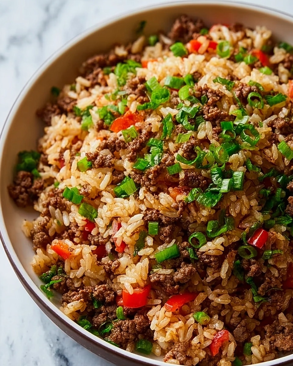 A close-up view of a bowl filled with cooked white rice mixed with browned ground beef, small pieces of red bell pepper, and chopped green celery and parsley. The rice grains look fluffy and slightly shiny, while the beef is crumbly and well-cooked, showing a deep brown color. The red bell pepper pieces add bright spots of color, and the green vegetables provide a fresh contrast scattered evenly throughout the dish. The bowl is white and sits on a white marbled surface, giving a clean and simple look. photo taken with an iphone --ar 4:5 --v 7