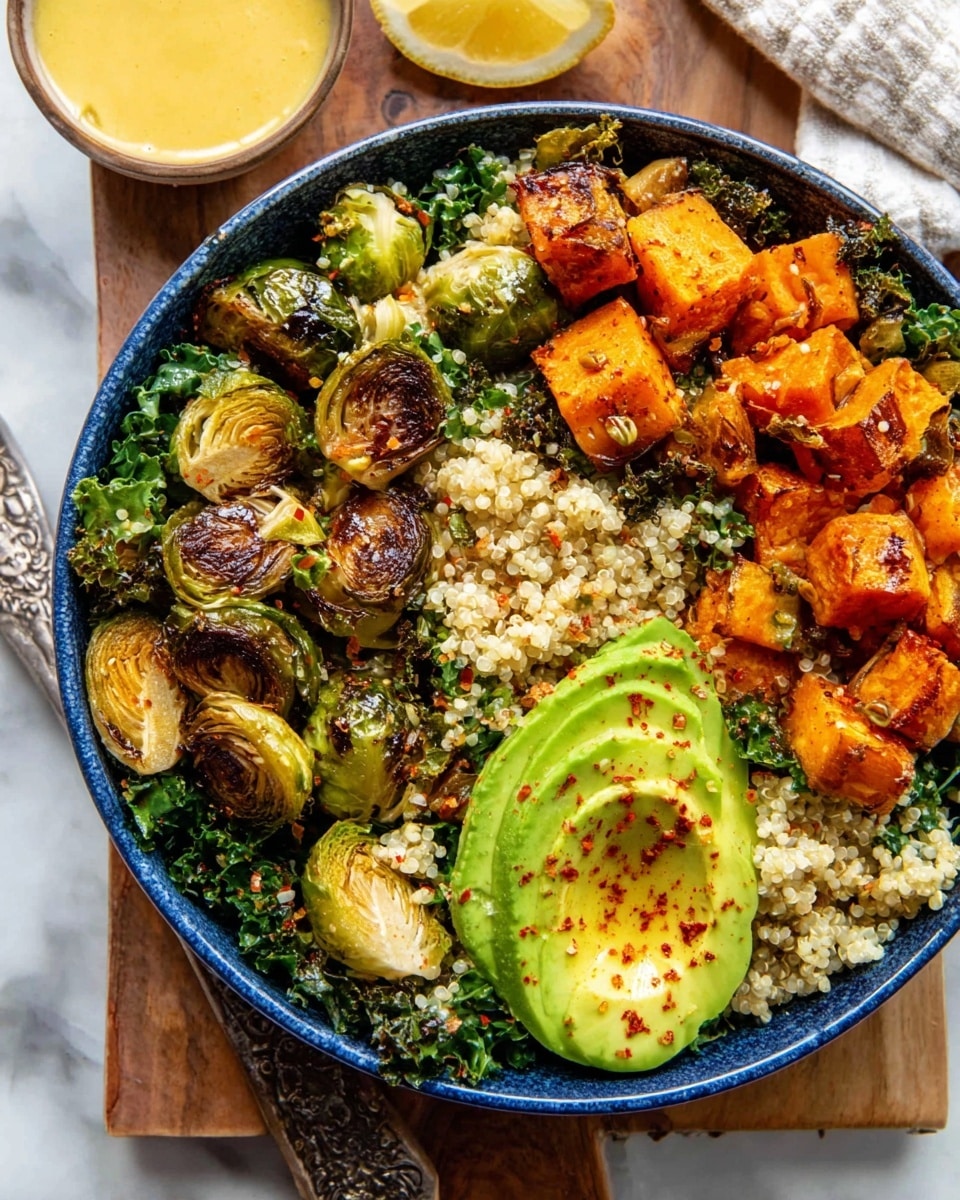 A white bowl filled with a three-layer salad starts with a base of light-colored quinoa mixed with chopped green kale. On left side, golden-brown roasted Brussels sprouts are spread over the quinoa. The right side features bright orange roasted sweet potato cubes. Two thick slices of green avocado, lightly sprinkled with spices, rest on top near the left and bottom edges. Two pale yellow lemon wedges sit on the right side next to a silver spoon. The bowl is placed on a white marbled surface with a rustic wooden board holding a small white bowl of golden dressing above it and a small wooden spoon with reddish spice to the right. A dusty pink cloth peeks from the bottom left corner. photo taken with an iphone --ar 4:5 --v 7