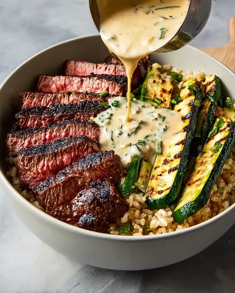 A deep white bowl holds a vibrant dish with four visible layers: at the bottom is a bed of brown rice, slightly textured and filling the bowl base; on one side, slices of grilled steak with a rich dark brown char on the edges and medium-rare pink centers are arranged in a fan-like pattern; next to the steak, long slices of grilled zucchini with dark grill marks show a glossy green surface and soft texture; in the center, creamy sauce with a pale beige color and flecks of green herbs is being poured from a ladle, partially covering the steak and rice underneath. The bowl sits on a white marbled surface. Photo taken with an iphone --ar 4:5 --v 7