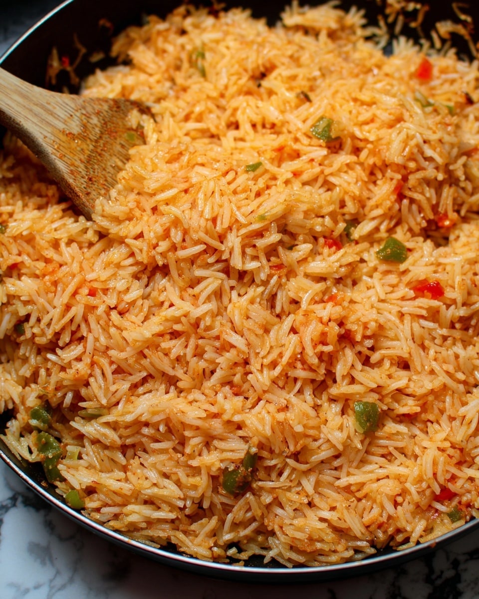 A close-up view of a single layer of cooked orange-red rice with small pieces of vegetables mixed in, shown scooped on a light brown wooden spoon inside a black cooking pot with silver rivets on the sides, with the rice grains appearing moist and fluffy. The background is a white marbled texture. photo taken with an iphone --ar 4:5 --v 7