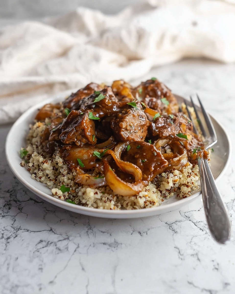 The dish shows a white plate with a base layer of cooked rice mixed with quinoa, giving a textured look with small grains in light brown and dark colors. On top, there are cooked onion slices that are caramelized to a golden-brown color, adding a soft yet slightly crisp layer. The top layer is made of chunky pieces of browned meat covered in a thick, glossy brown sauce. Small bits of green herbs are sprinkled over the dish, adding a fresh touch. A silver fork rests on the right side of the plate, and the setup sits on a white marbled surface with a soft, white cloth in the background. photo taken with an iphone --ar 4:5 --v 7
