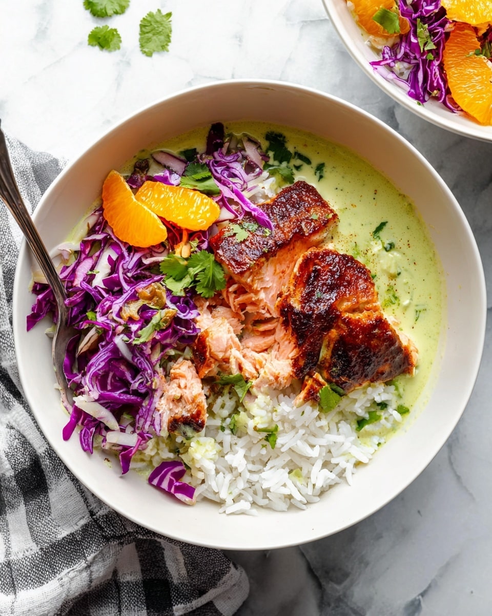 A white bowl filled with fluffy white rice forms the base layer, with a smooth light green creamy sauce spread along one side. On top of the rice, there is a piece of cooked salmon with a crispy, dark brown crust, broken into uneven chunks revealing tender pink flesh inside. Bright purple shredded cabbage is scattered around the salmon, mixed with vibrant orange citrus segments and sprinkled lightly with green cilantro leaves. A silver spoon dips into the bowl, scooping up rice and sauce, with an edge just touching the salmon. The bowl rests on a white marbled surface with a grey and white checkered cloth nearby. Photo taken with an iphone --ar 4:5 --v 7