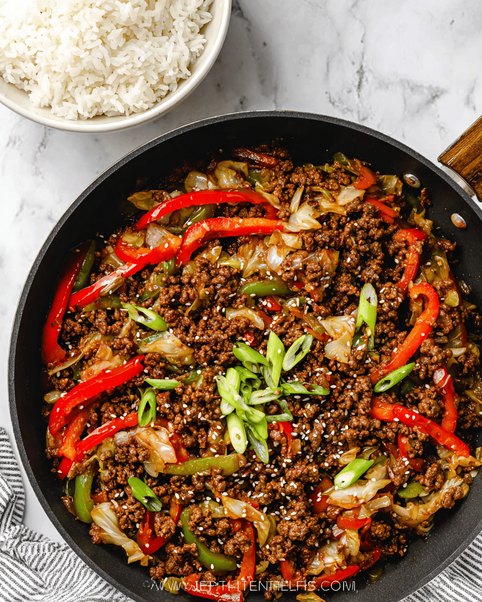 A black pan filled with cooked ground beef mixed with sliced red bell peppers, green celery, light brown cabbage, and onions, all coated in a shiny dark brown sauce. The dish is topped with a few pieces of chopped green onions and sprinkled with white sesame seeds. Next to the pan is a white bowl filled with fluffy white rice. The pan and bowl are placed on a white marbled surface, with part of a striped gray and white cloth visible nearby. photo taken with an iphone --ar 4:5 --v 7
