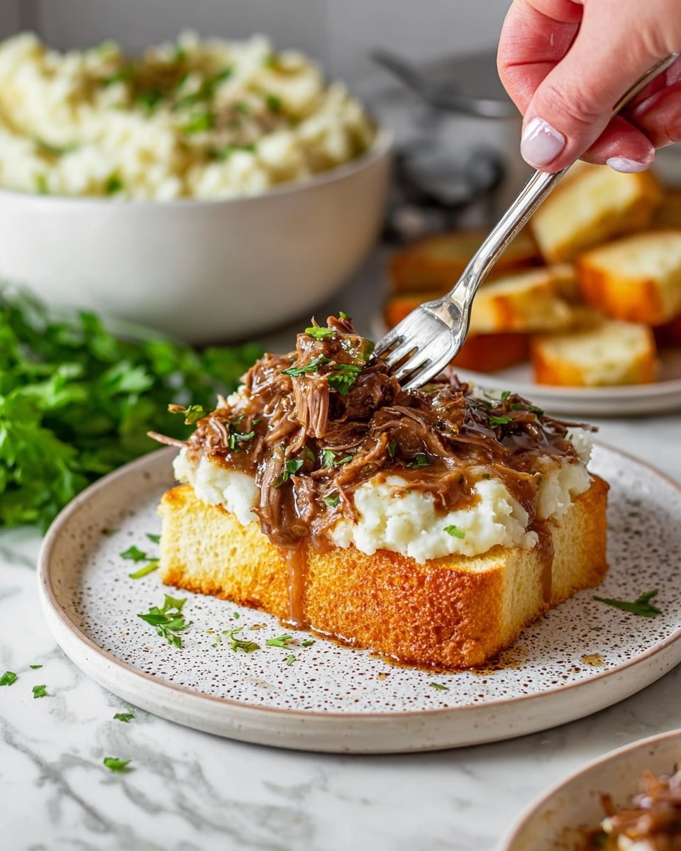 A white plate with a speckled design holds an open-faced sandwich made of three visible layers: the bottom layer is a thick slice of golden toasted bread with a crispy texture, the middle layer is a generous portion of fluffy white mashed potatoes, and the top layer is shredded juicy brown beef with a glossy sauce, garnished with small bits of green herbs. A woman's hand is using a fork to pull apart the beef on top. In the background, a white bowl filled with more mashed potatoes and pieces of toasted bread rest on a white marbled surface, along with some green leafy herbs nearby. Photo taken with an iphone --ar 4:5 --v 7